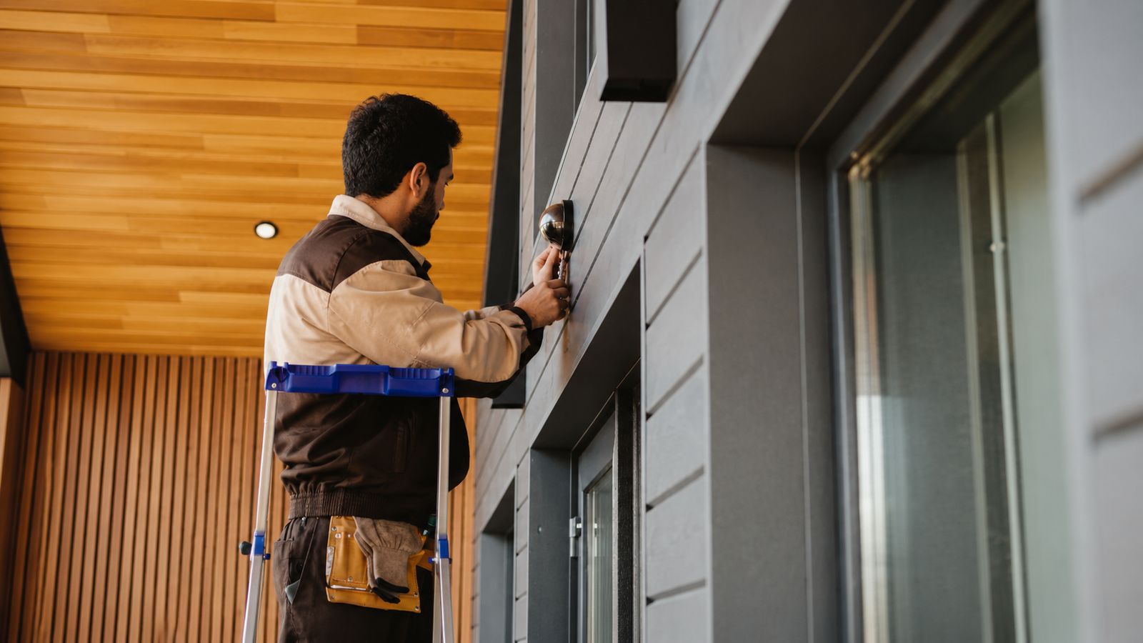 precisionpounds technician installing a fixture on a home exterior