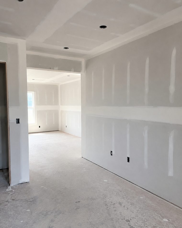 Freshly hung and taped drywall in a new room